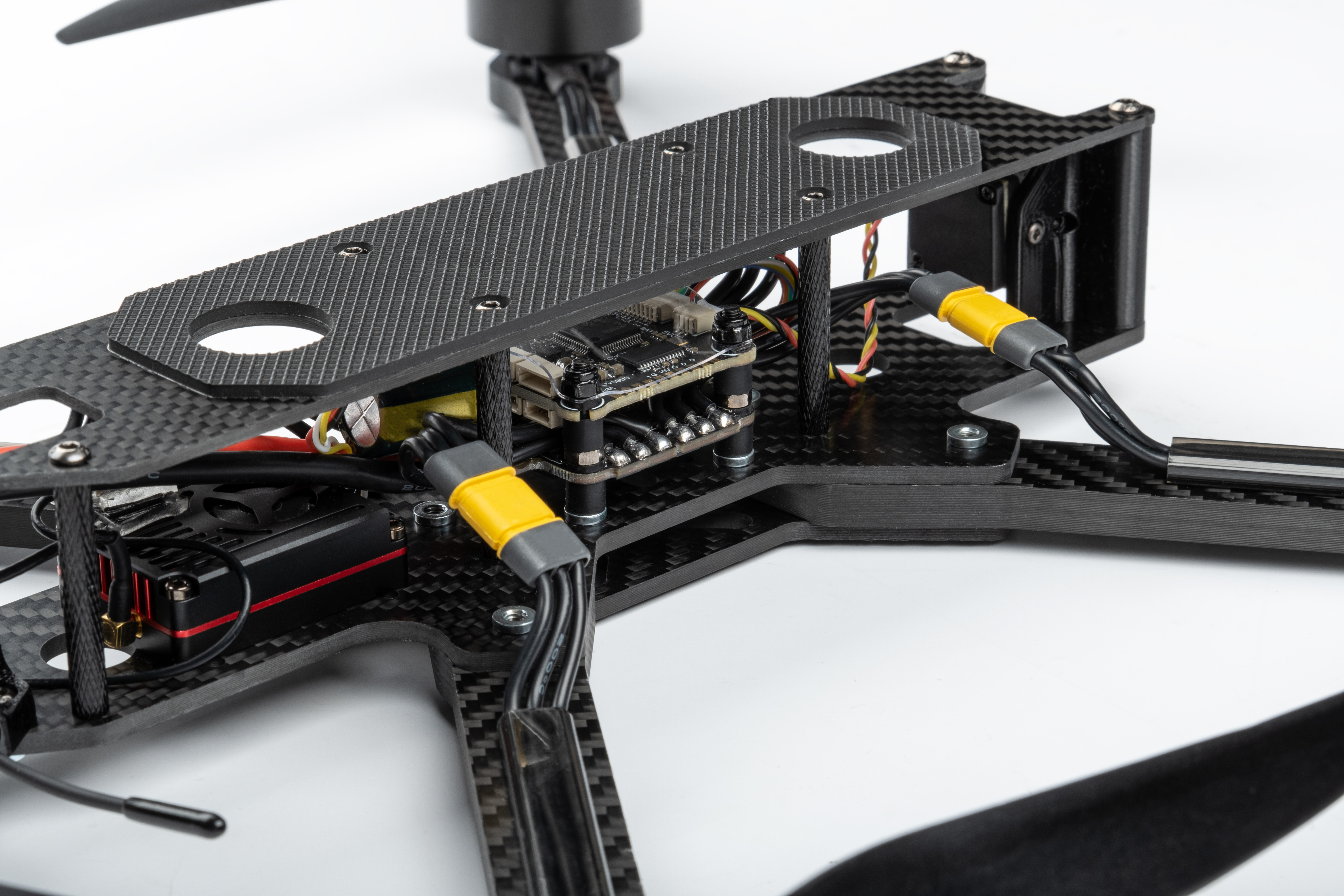 Close-up of a lightweight carbon fiber composite drone frame and electronic components, showing the high-strength structural materials used in drone and UAV applications.