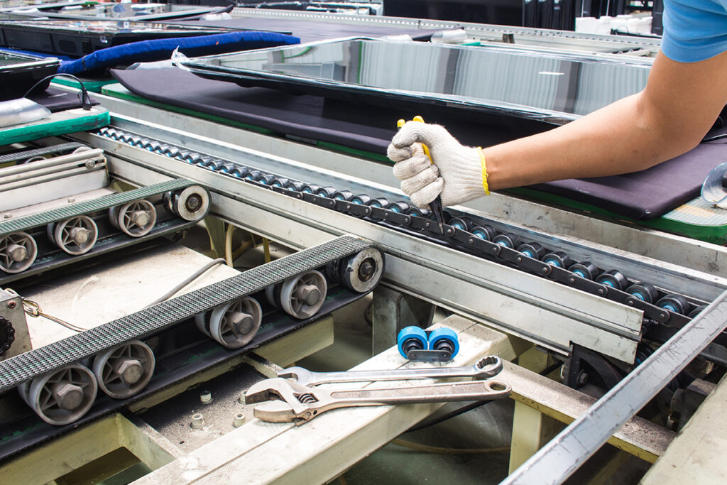 Technician repairing a conveyor line, a common emergency repair that needs cut-to-size plastic bearings and parts